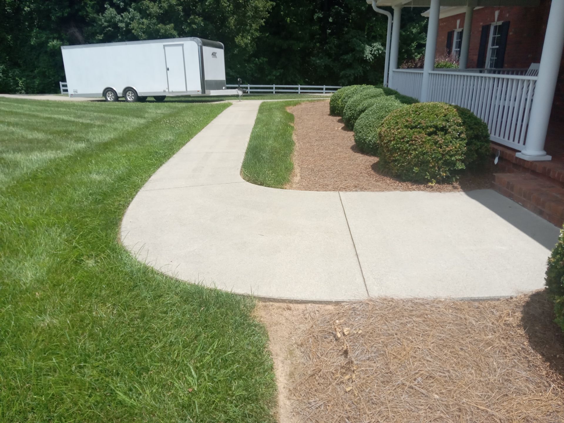 pressure washing concrete walkway and driveway surfaces to remove dirt and stains restoring clean appearance