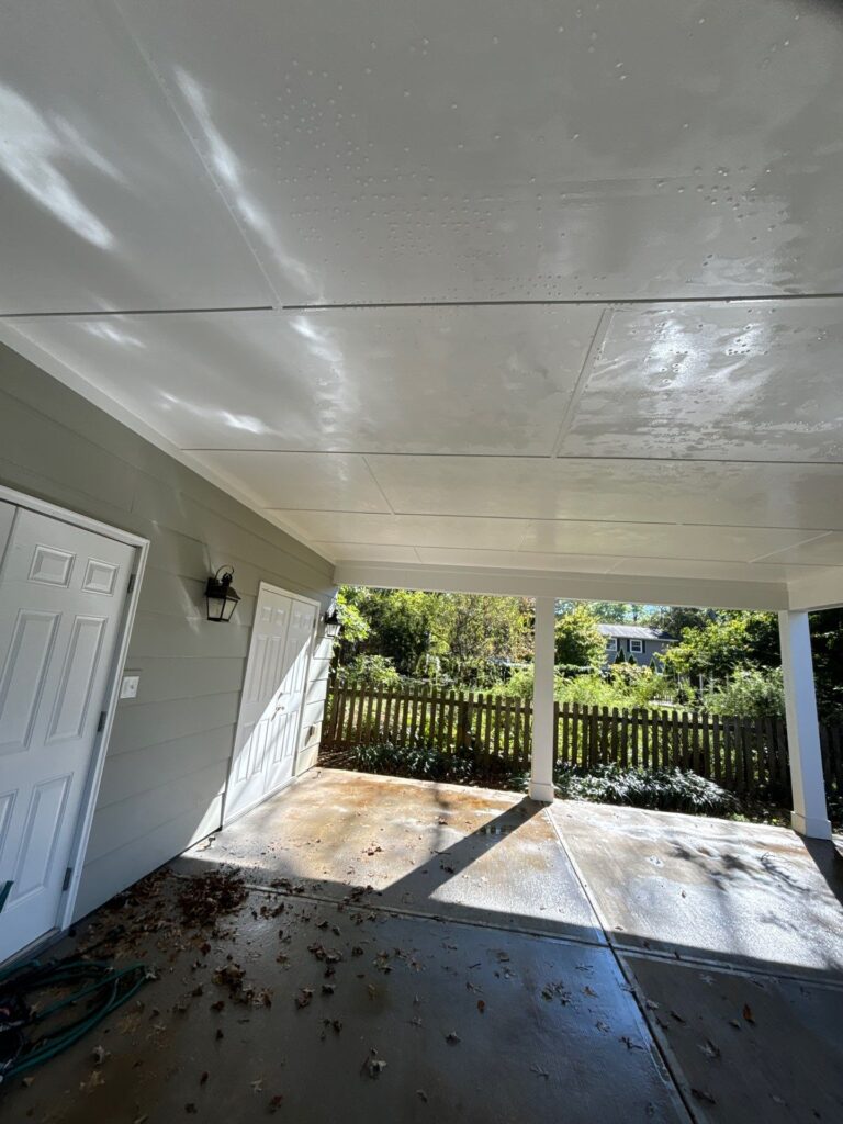 cleaning of a concrete patio area and ceiling using pressure washing techniques to remove dirt and debris