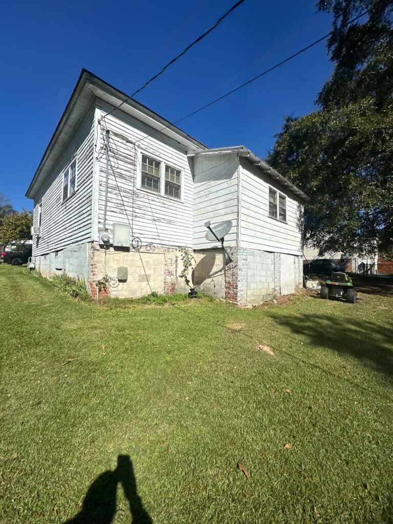 cleaning the exterior walls of a house with a focus on wood and brick surfaces