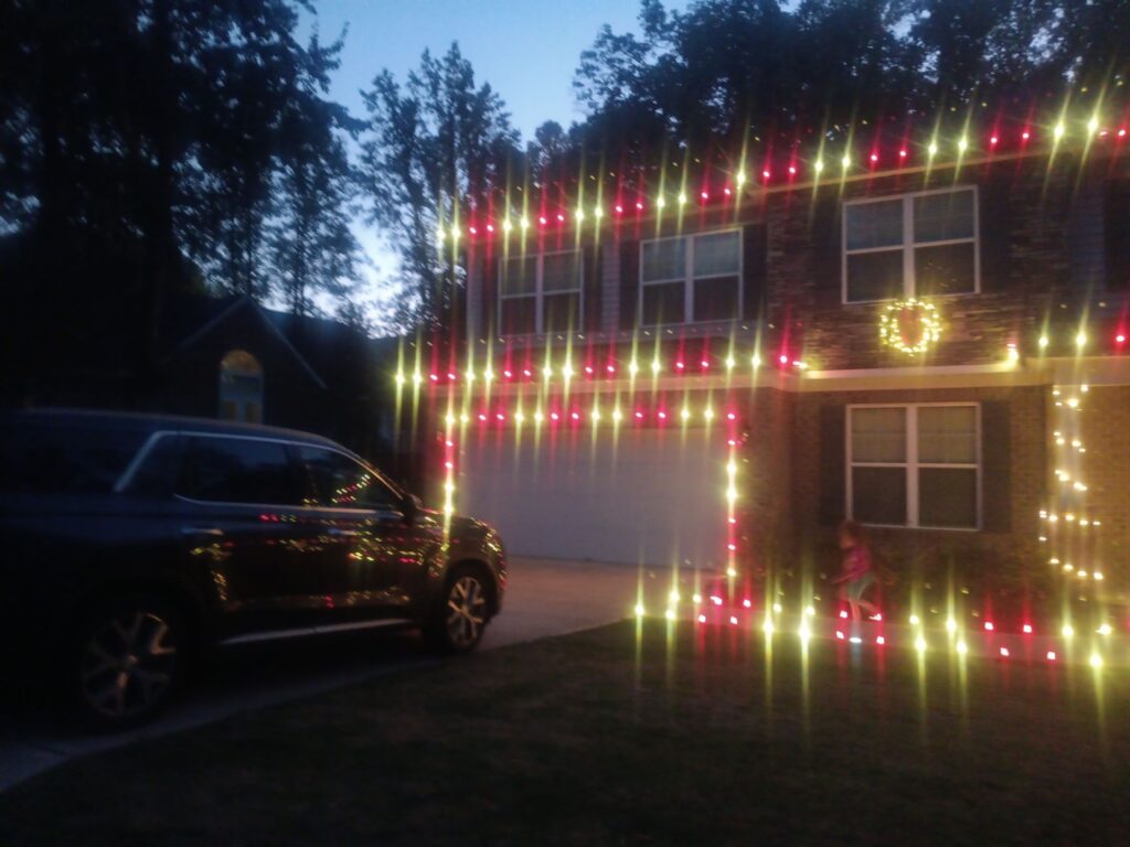 pressure washing and cleaning of brick and windows on a house decorated with holiday lights