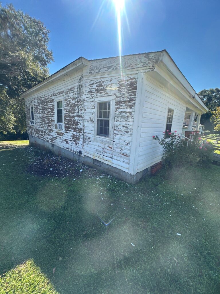 the service being done is cleaning and removing peeling paint from the exterior of a house