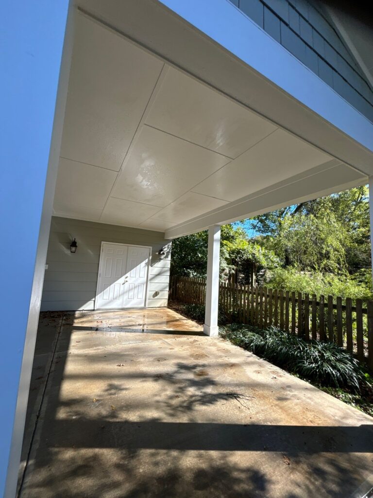 the service being done is cleaning the concrete surface of a patio area under a house using pressure washing techniques