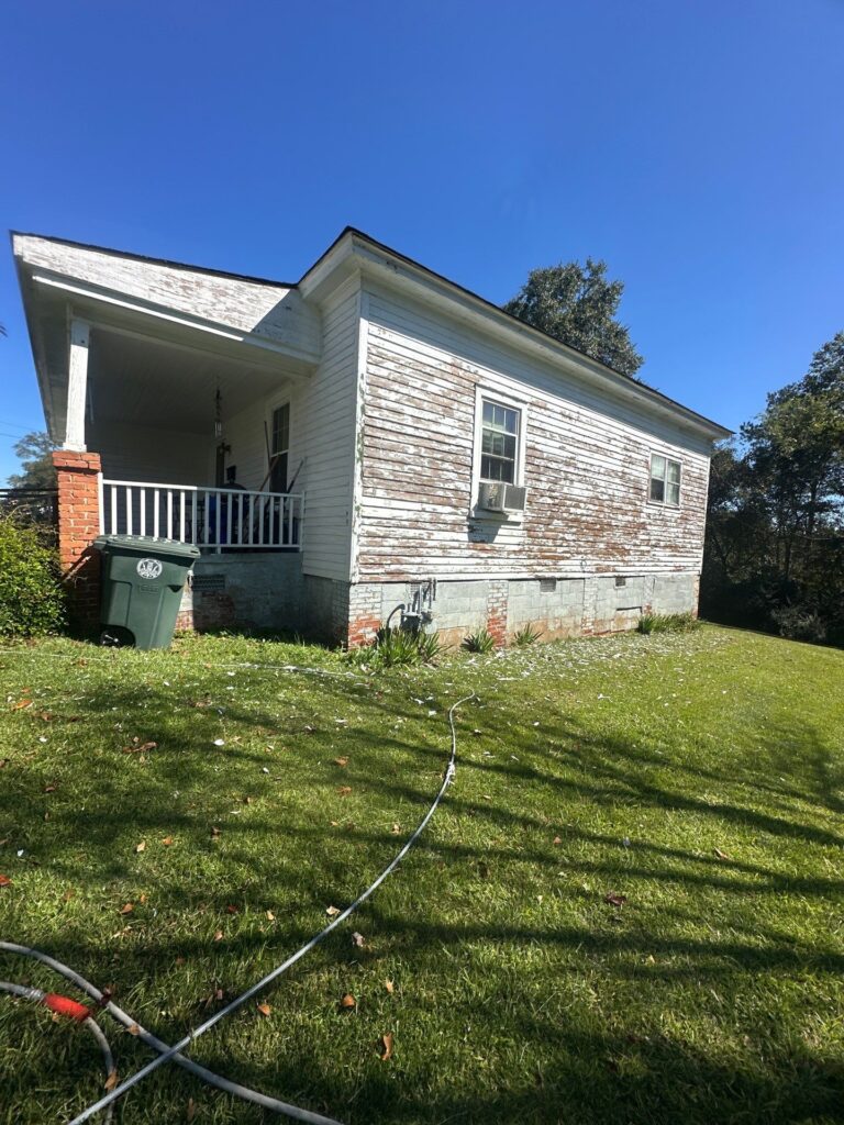 the service being done is pressure washing the exterior of a house to remove dirt and peeling paint from the surface