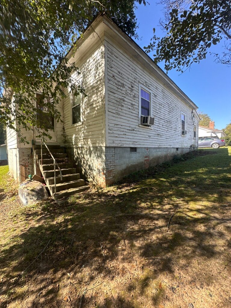 the service shown is cleaning the exterior of a house and its surrounding area likely removing dirt and grime