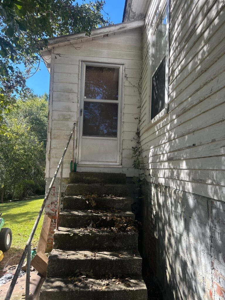 the service shown is cleaning the exterior siding and steps of a house to remove dirt and debris