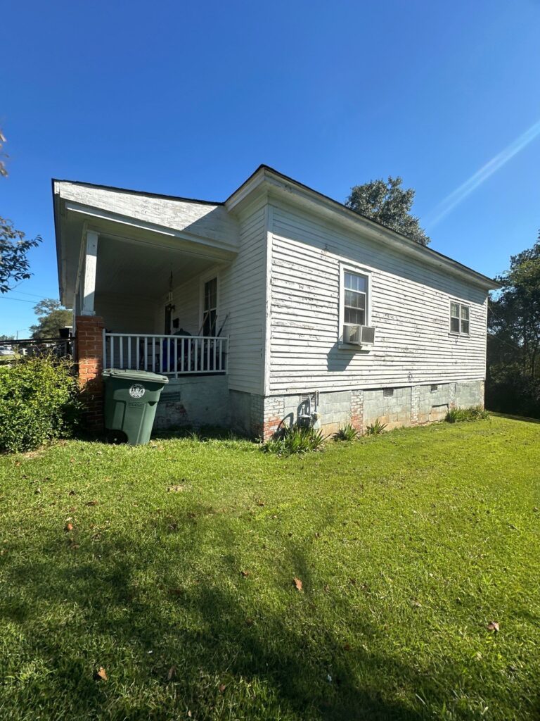 the service shown is likely pressure washing the exterior wood siding of the house and cleaning the surrounding areas